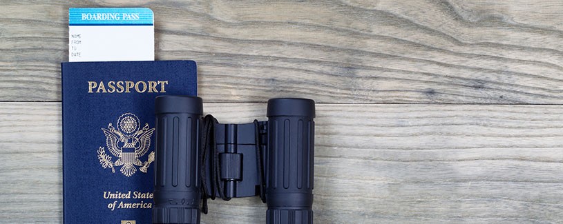 United States Passport and Binoculars on wood
