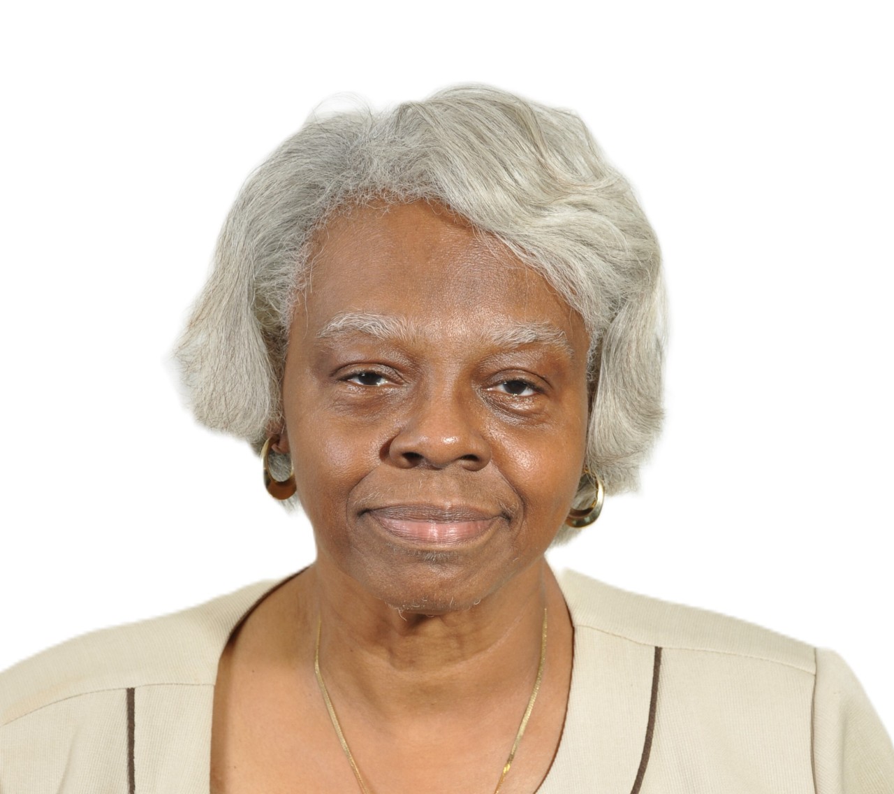 An elderly woman standing in front of a plain, white background.